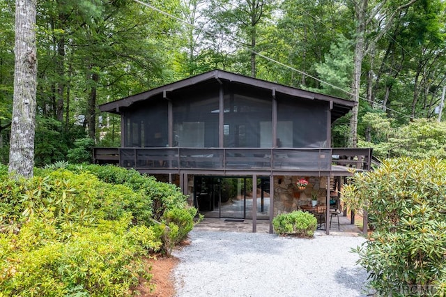 chalet / cabin with a sunroom, a patio area, and a deck