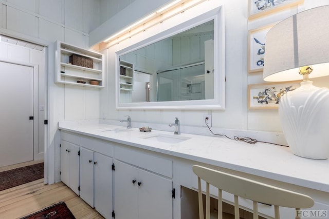 full bathroom with wood finished floors, a sink, and double vanity
