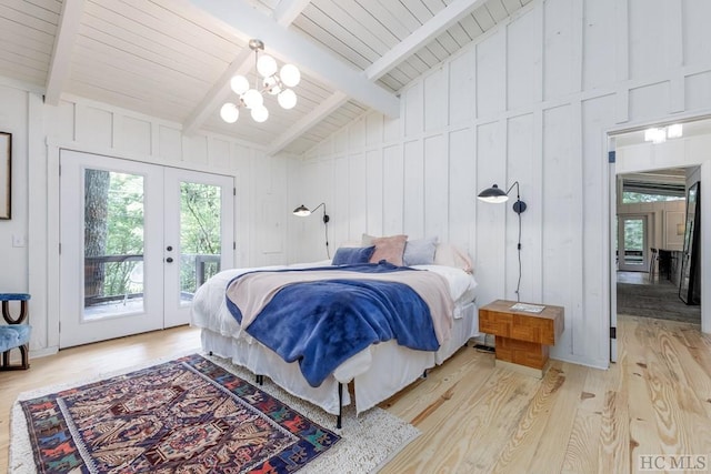 bedroom featuring lofted ceiling with beams, french doors, light wood-style flooring, a notable chandelier, and access to outside