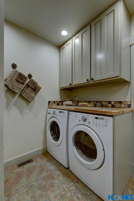 178 Whetstone Gap Rd, Lake Toxaway, NC 28747 - washroom featuring cabinet space, independent washer and dryer, baseboards, and stone finish flooring