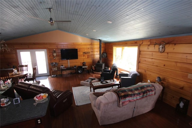 living room with a healthy amount of sunlight, a wood stove, lofted ceiling, and wood finished floors