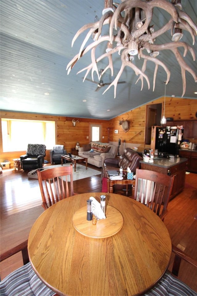 dining room featuring wood finished floors and wood walls