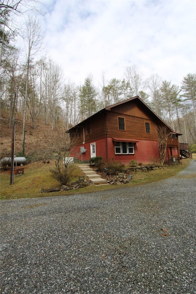 view of side of home featuring gravel driveway