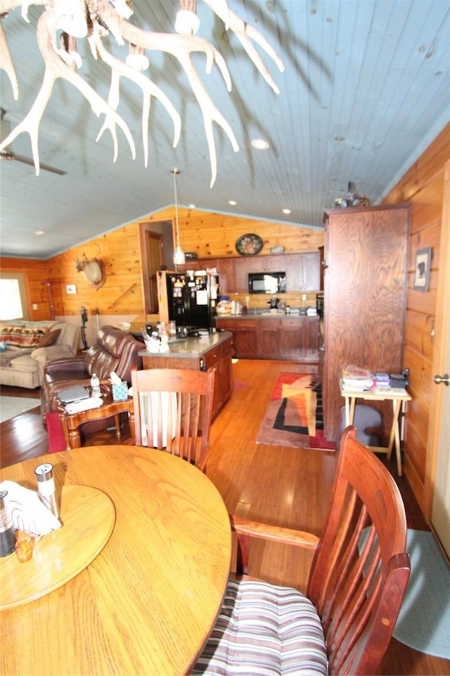 dining area featuring wood ceiling, wooden walls, and light wood-style floors