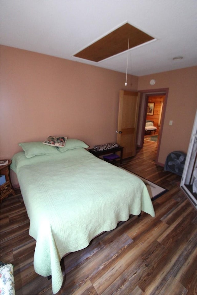 bedroom with attic access and wood finished floors