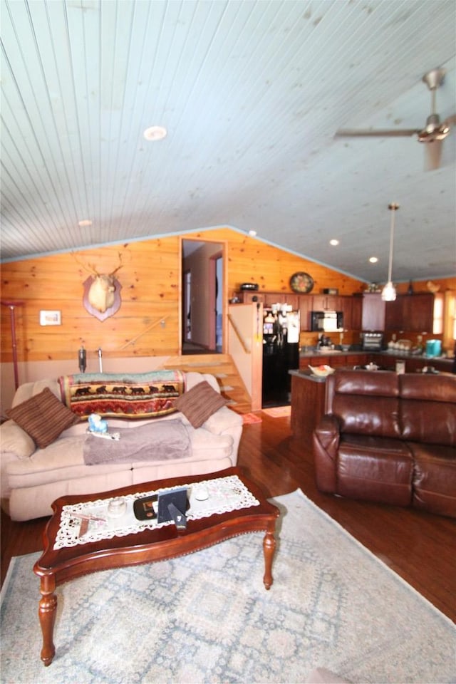 living room with wood finished floors, wooden ceiling, wood walls, lofted ceiling, and ceiling fan