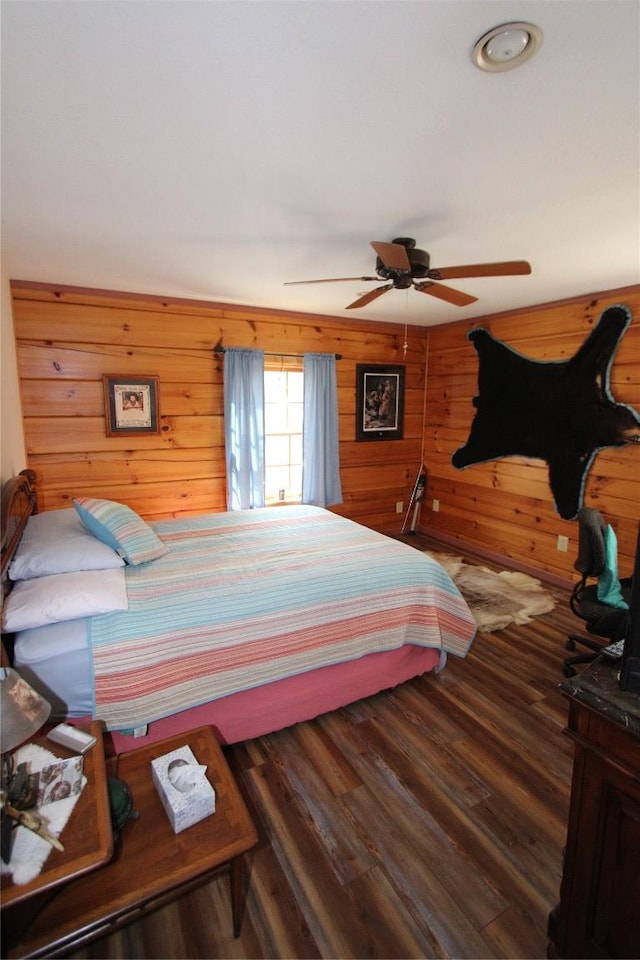 bedroom featuring wood walls, ceiling fan, and wood finished floors