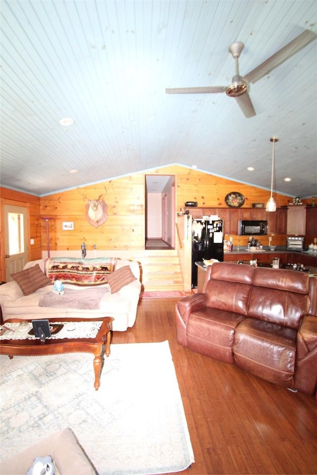 living area featuring wood ceiling, vaulted ceiling, wooden walls, and wood finished floors