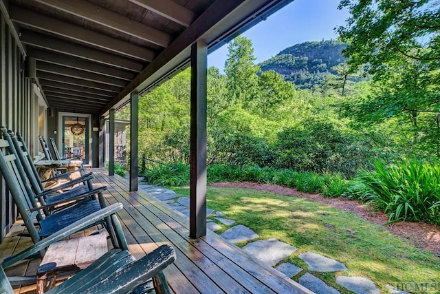 wooden terrace with a mountain view and a yard