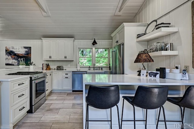 kitchen featuring white cabinetry, kitchen peninsula, high quality appliances, and a kitchen breakfast bar