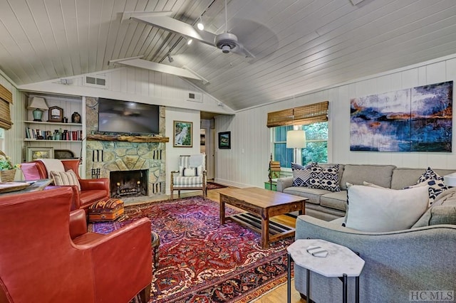 living room with hardwood / wood-style flooring, a stone fireplace, wooden ceiling, ceiling fan, and built in features