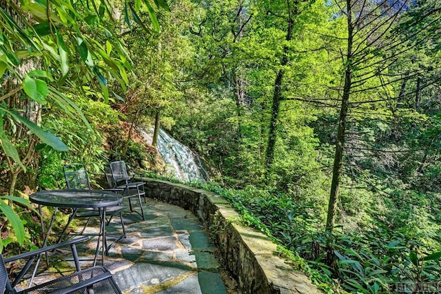 view of patio / terrace with a forest view and outdoor dining area