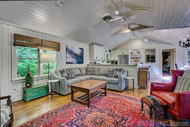 living room with light wood-type flooring, wooden ceiling, lofted ceiling with beams, and ceiling fan with notable chandelier