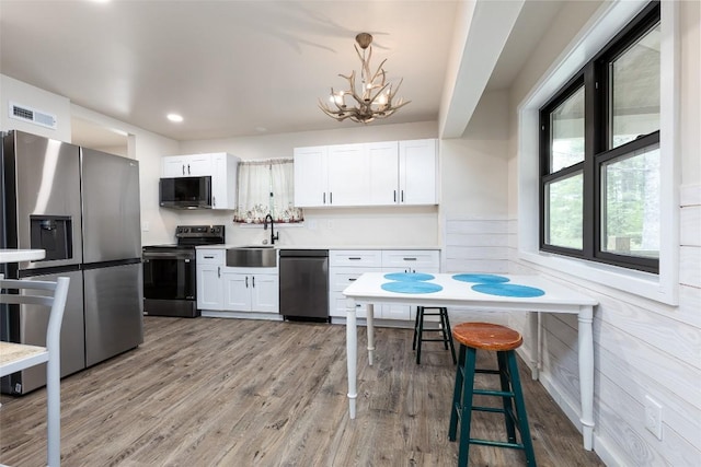 67 Chipmunk Trl, Glenville, NC 28736 - kitchen featuring stainless steel appliances, a sink, a chandelier, white cabinetry, and pendant lighting