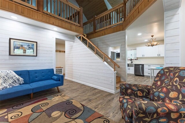 67 Chipmunk Trl, Glenville, NC 28736 - living room featuring wood finished floors, stairs, a high ceiling, wood walls, and baseboards