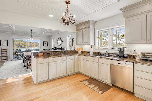 kitchen with dishwashing machine, a chandelier, a peninsula, light wood-style floors, and a sink