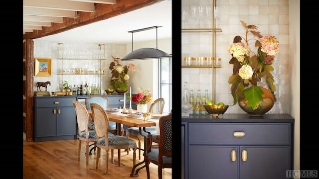 bar with hanging light fixtures, blue cabinetry, beamed ceiling, and hardwood / wood-style flooring