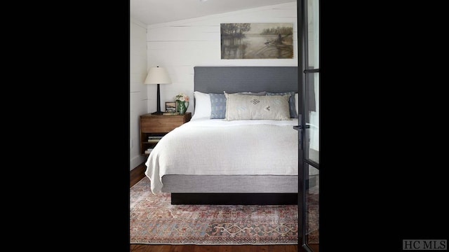 bedroom with lofted ceiling and dark hardwood / wood-style flooring