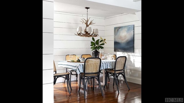 dining area with dark hardwood / wood-style floors and a notable chandelier