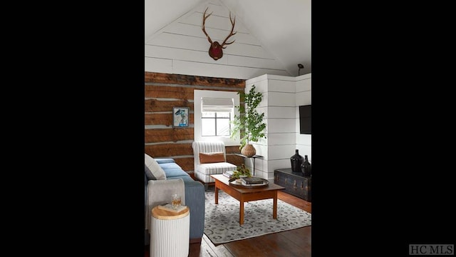 living room with wooden walls, wood-type flooring, and lofted ceiling