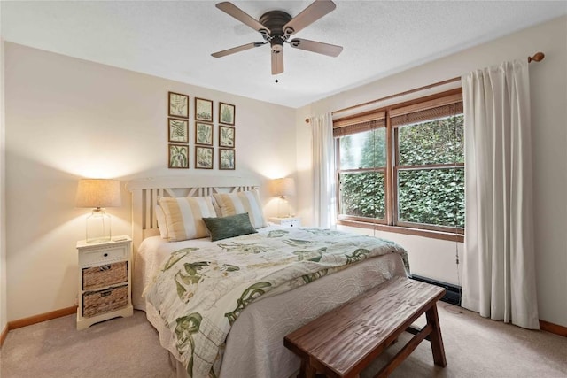 bedroom with light colored carpet, baseboards, and a ceiling fan