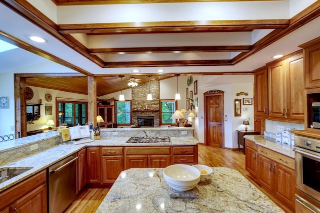 40 Piney Ridge Ct, Sapphire, NC 28774 - kitchen featuring stainless steel appliances, a large fireplace, light wood finished floors, and light stone counters