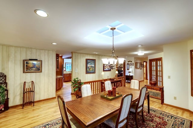 40 Piney Ridge Ct, Sapphire, NC 28774 - dining area with a chandelier, light wood-style floors, wooden walls, a skylight, and recessed lighting