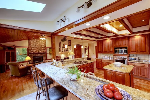 40 Piney Ridge Ct, Sapphire, NC 28774 - kitchen featuring stainless steel appliances, open floor plan, a fireplace, light wood-style flooring, and ornamental molding