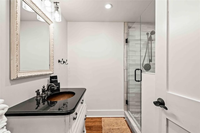 full bathroom with a stall shower, vanity, wood finished floors, baseboards, and recessed lighting