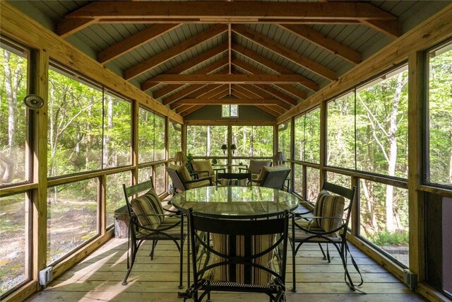 sunroom with outdoor dining area and lofted ceiling