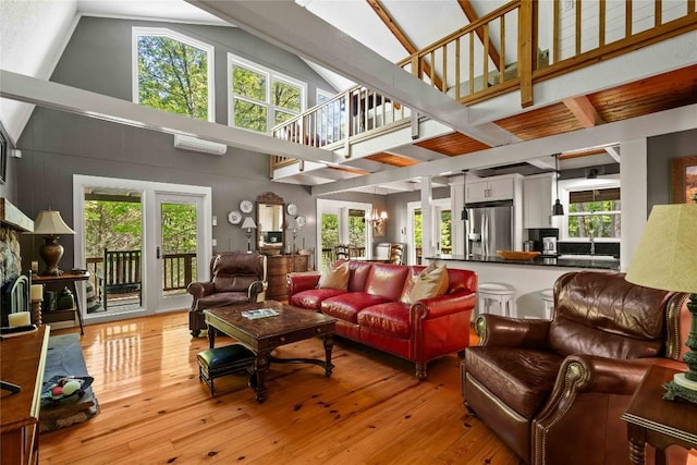 living room with high vaulted ceiling, wood-type flooring, healthy amount of natural light, french doors, and beam ceiling