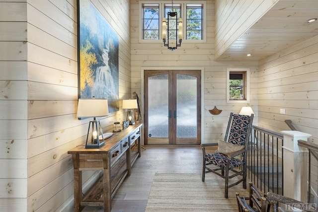 interior space with wooden walls, french doors, and wood-type flooring