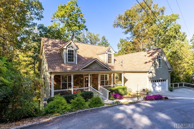 new england style home with covered porch and a garage