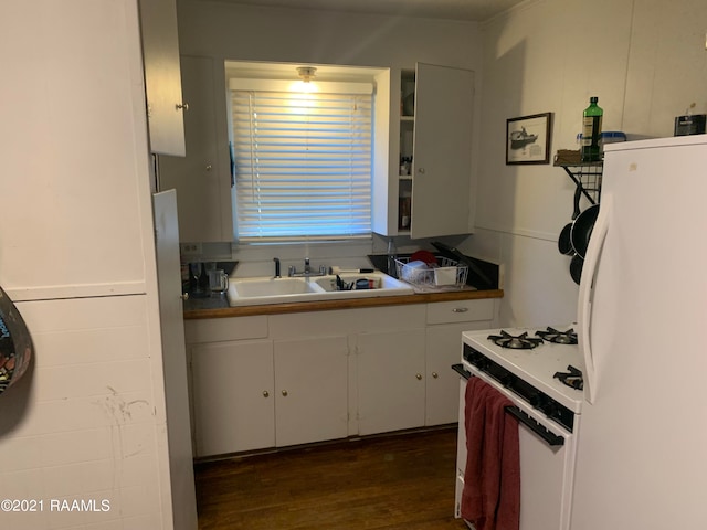 kitchen with white appliances, white cabinets, dark hardwood / wood-style floors, and sink