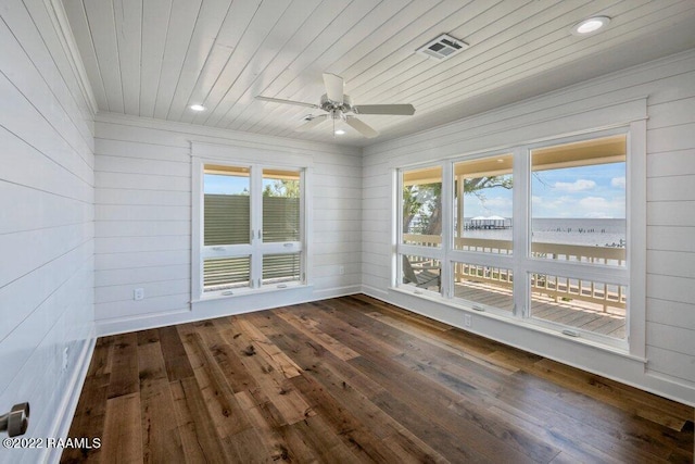 unfurnished room featuring ceiling fan, dark hardwood / wood-style floors, and wooden ceiling