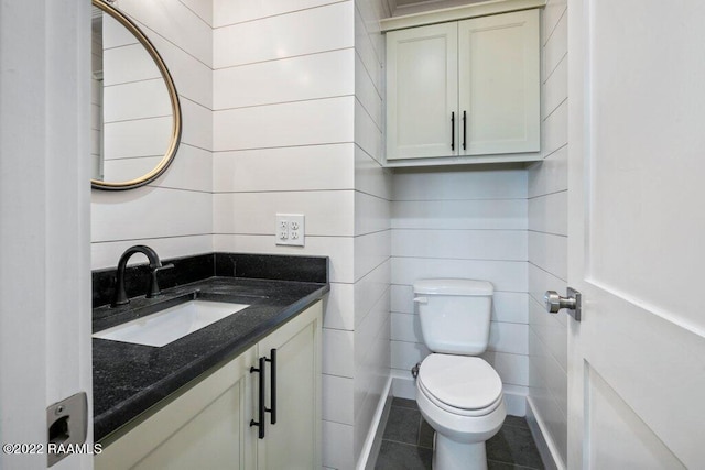 bathroom with toilet, tile flooring, and vanity