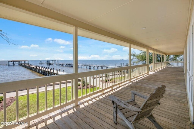 wooden terrace featuring a lawn and a water view