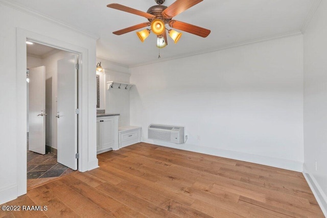 spare room featuring ceiling fan, tile floors, ornamental molding, and an AC wall unit