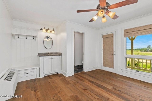 interior space with ceiling fan, sink, ornamental molding, and dark hardwood / wood-style flooring