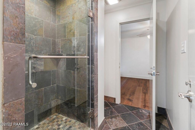 bathroom featuring hardwood / wood-style floors, a shower with door, and ornamental molding