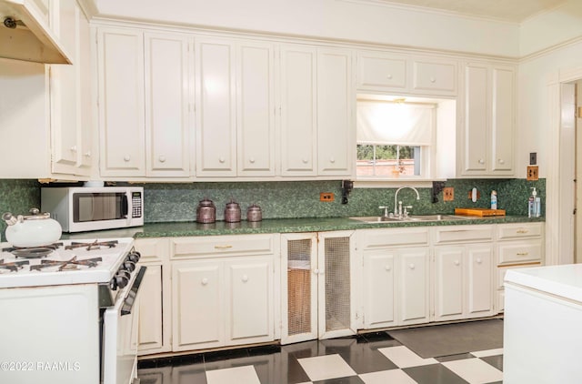 kitchen with sink, white appliances, backsplash, and dark tile flooring