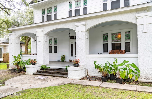 view of exterior entry featuring covered porch