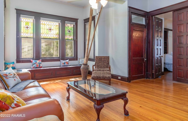 living room with ceiling fan, light wood-type flooring, and a wealth of natural light