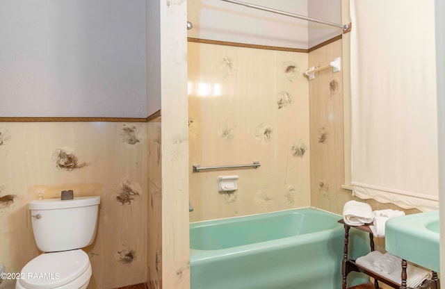 bathroom featuring washtub / shower combination and toilet