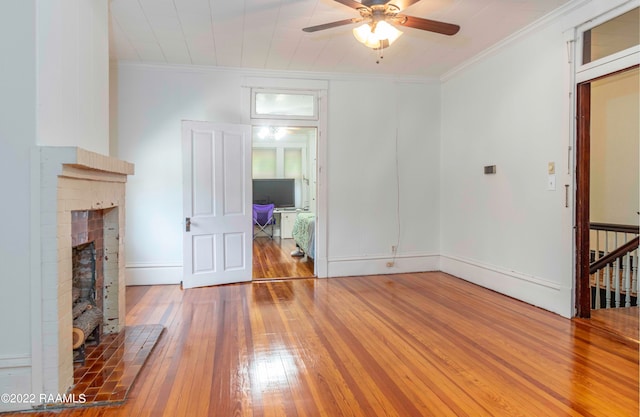 unfurnished living room with dark hardwood / wood-style flooring, ceiling fan, and a brick fireplace