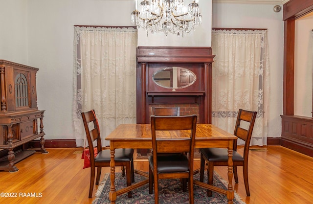 dining area with light hardwood / wood-style flooring and an inviting chandelier