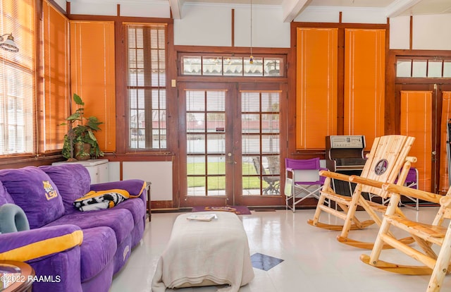 interior space with light tile floors, french doors, and ornamental molding