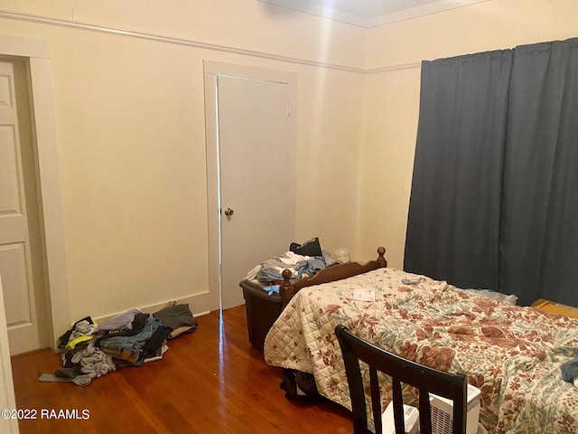 bedroom with dark hardwood / wood-style flooring, a closet, and ornamental molding