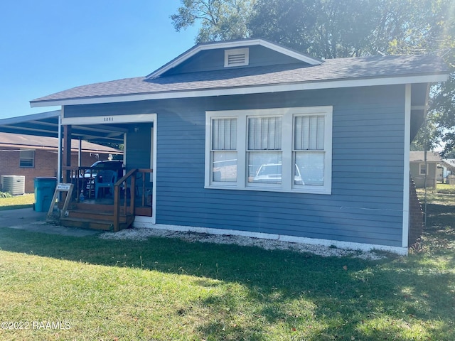 rear view of house with a lawn and central AC unit