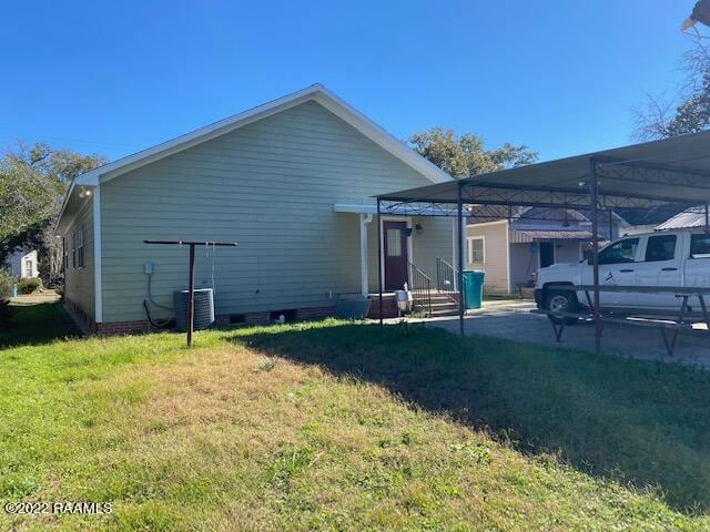 back of house featuring a yard and central air condition unit